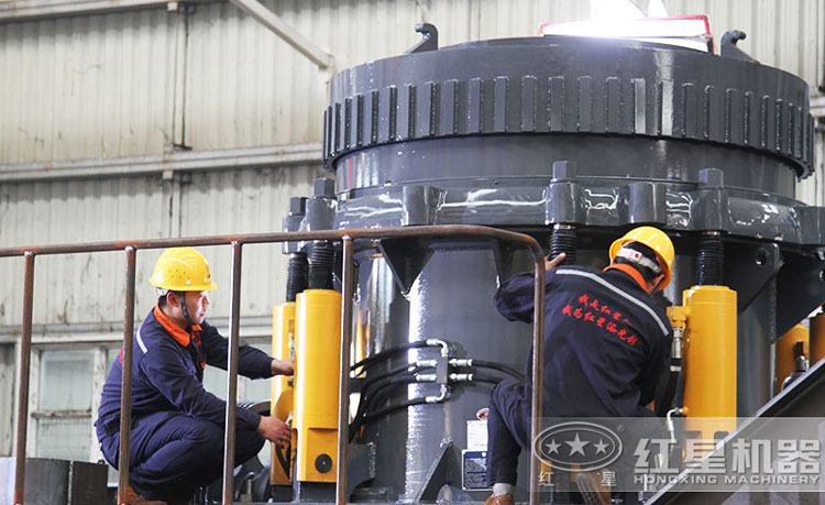 工作人員檢測(cè)圓錐破碎機(jī)，保障生產(chǎn)的設(shè)備都有高質(zhì)量